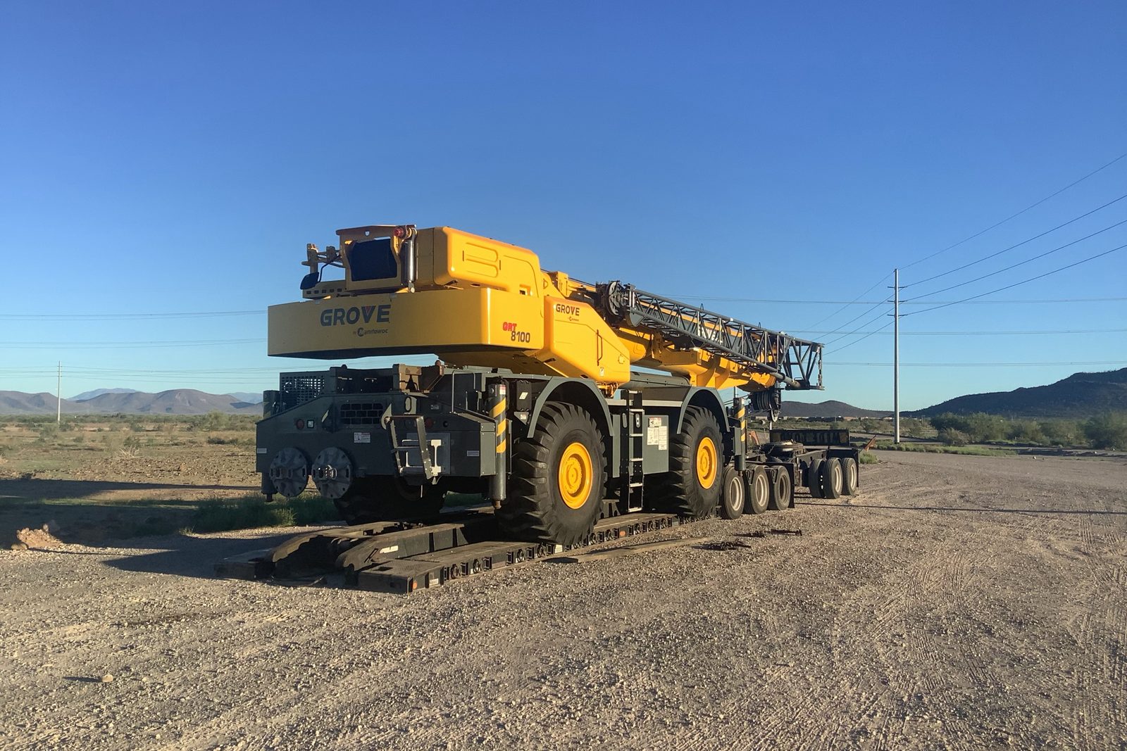 Grove GRT8100 rough terrain crane secured on a lowboy in the Arizona desert